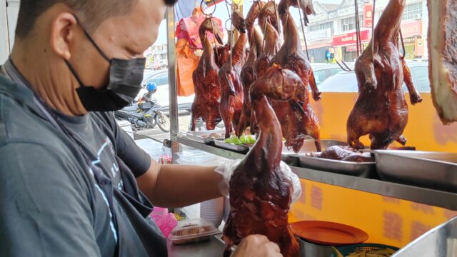 Muyan Anak Rayang, founder of Yang Kee Herbal Roasted Duck, serving roasted duck rice in Taman Universiti, Skudai, Johor Bahru.
