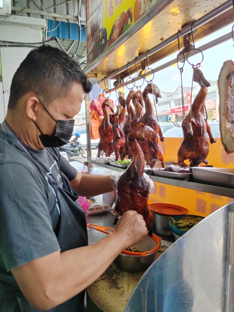 Muyan Anak Rayang, founder of Yang Kee Herbal Roasted Duck, serving roasted duck rice in Taman Universiti, Skudai, Johor Bahru.